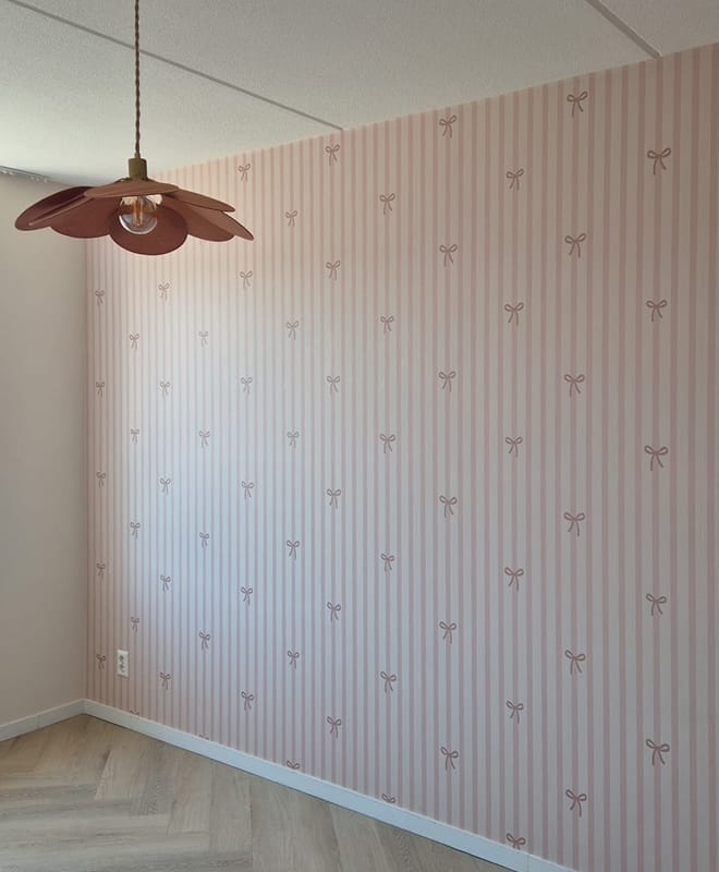 Oudroze strikjesbehang in de meisjeskamer